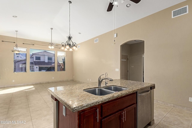 kitchen featuring pendant lighting, dishwasher, an island with sink, sink, and light tile patterned floors