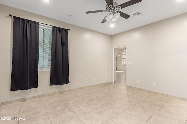 tiled spare room featuring ceiling fan