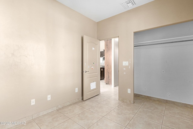 unfurnished bedroom featuring light tile patterned floors and a closet