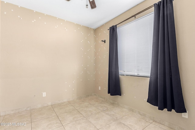 tiled empty room featuring ceiling fan