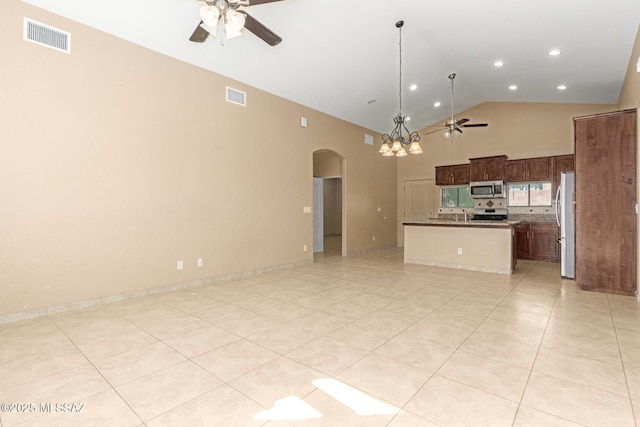 unfurnished living room with high vaulted ceiling, light tile patterned floors, and ceiling fan with notable chandelier