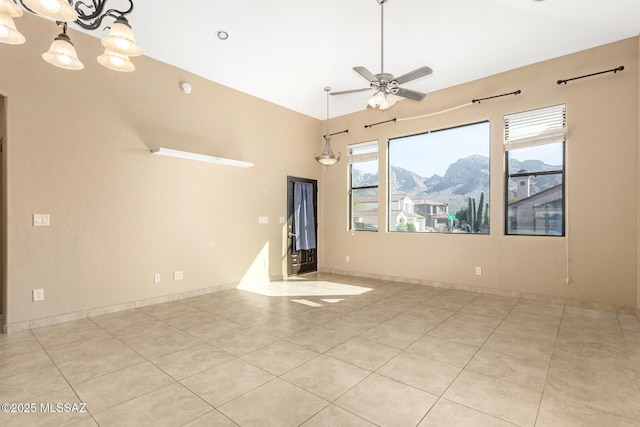 empty room with ceiling fan, light tile patterned flooring, and a mountain view