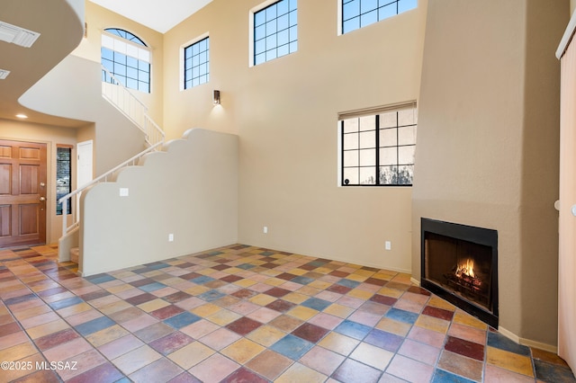 unfurnished living room featuring a high ceiling