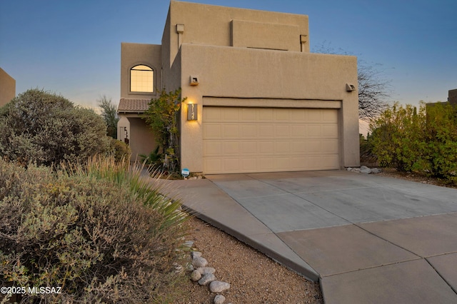 pueblo-style house featuring a garage