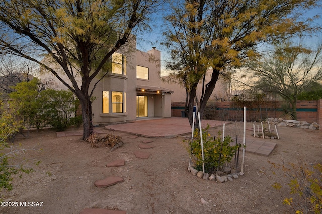 back house at dusk with a patio