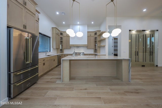 kitchen featuring sink, an island with sink, hanging light fixtures, and stainless steel appliances