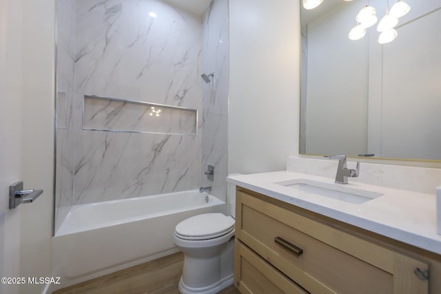 full bathroom featuring tiled shower / bath combo, hardwood / wood-style floors, toilet, and vanity