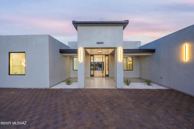 exterior entry at dusk featuring a patio area