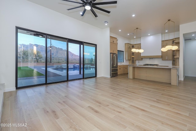 kitchen with a kitchen island, decorative light fixtures, light hardwood / wood-style floors, a mountain view, and ceiling fan