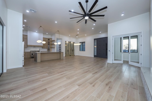 unfurnished living room featuring ceiling fan and light hardwood / wood-style flooring