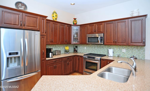 kitchen featuring stainless steel appliances, sink, and backsplash