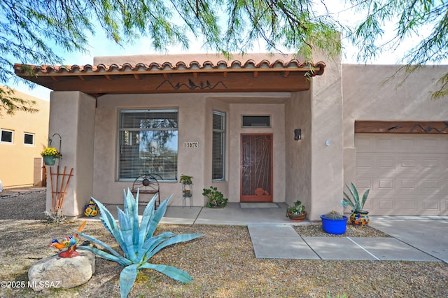 entrance to property featuring stucco siding and an attached garage