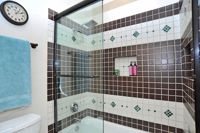 full bathroom with toilet and shower / bath combination with glass door