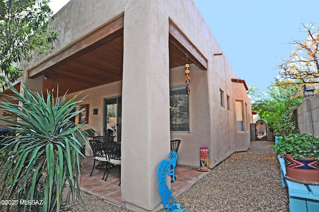 exterior space featuring stucco siding, a patio, and fence