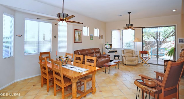 dining area featuring light tile patterned flooring, a ceiling fan, and baseboards