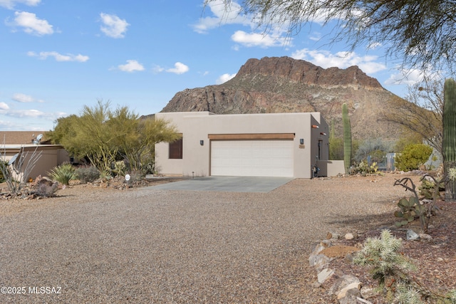 adobe home featuring a garage and a mountain view