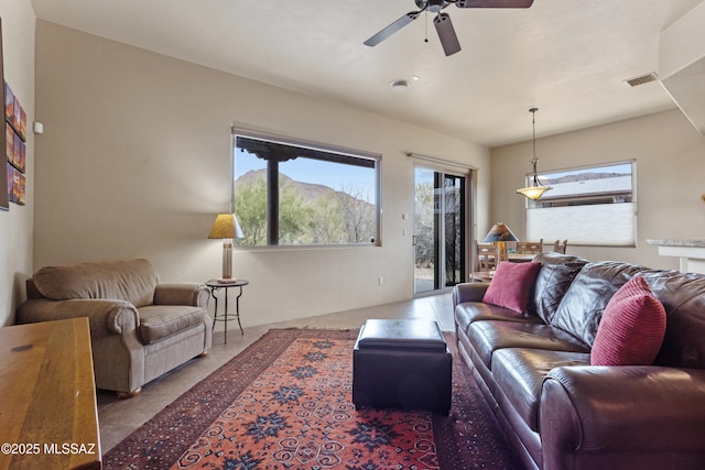 living room featuring tile patterned flooring, a mountain view, and ceiling fan