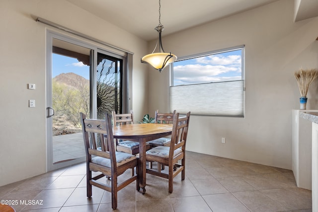 dining room with a mountain view and light tile patterned floors