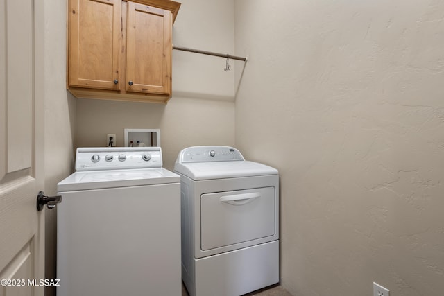 laundry area with washing machine and clothes dryer and cabinet space