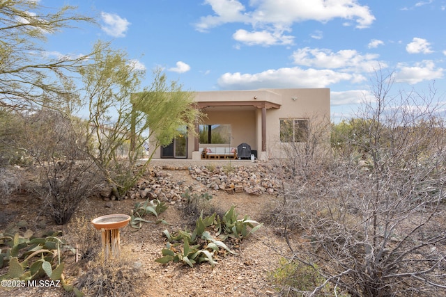 view of side of home with a patio area and stucco siding