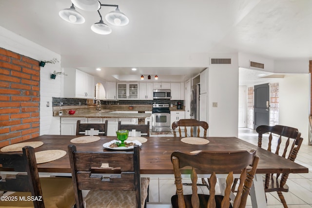 tiled dining space featuring sink