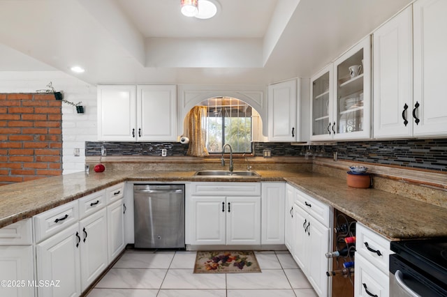 kitchen with sink, dishwasher, stone counters, a tray ceiling, and white cabinets