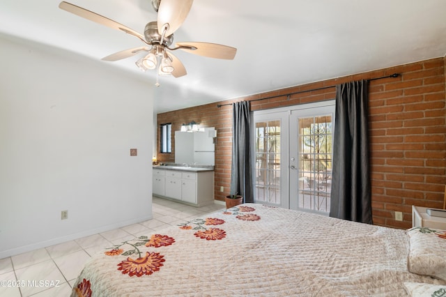 unfurnished bedroom featuring brick wall, light tile patterned floors, access to exterior, ceiling fan, and french doors