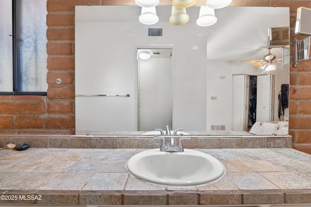 bathroom with vanity and ceiling fan with notable chandelier