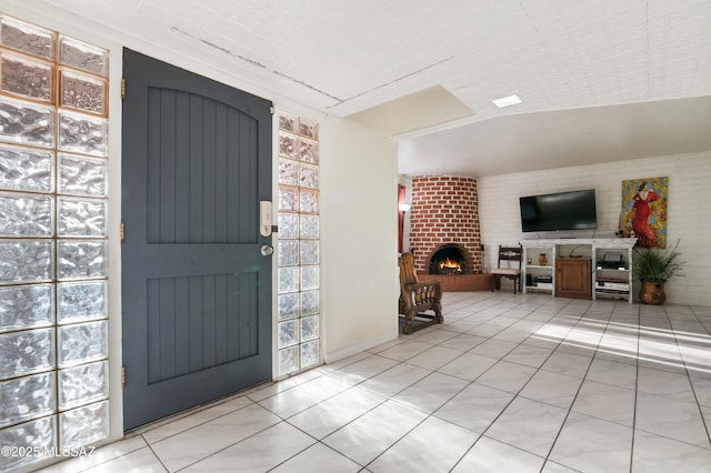 tiled entryway with a brick fireplace