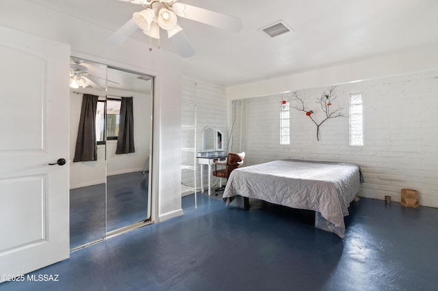 bedroom with brick wall, ceiling fan, and a closet