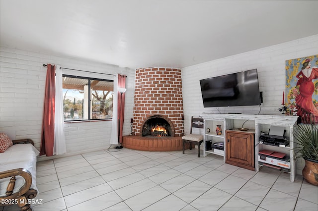 living room featuring a brick fireplace and brick wall