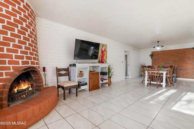 living room featuring ceiling fan, brick wall, and a brick fireplace