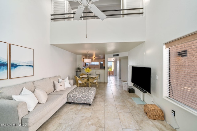 living room with light tile patterned flooring, a towering ceiling, and ceiling fan