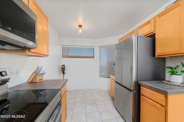 kitchen with light tile patterned floors and appliances with stainless steel finishes