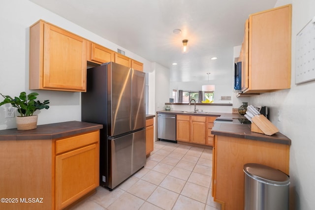 kitchen featuring sink, light brown cabinets, light tile patterned floors, appliances with stainless steel finishes, and kitchen peninsula