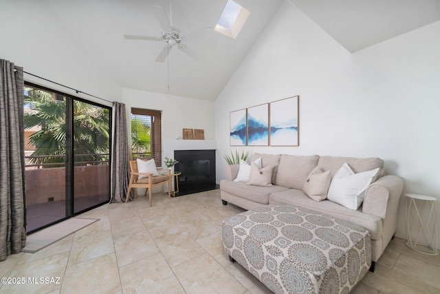 tiled living room featuring a skylight, high vaulted ceiling, and ceiling fan