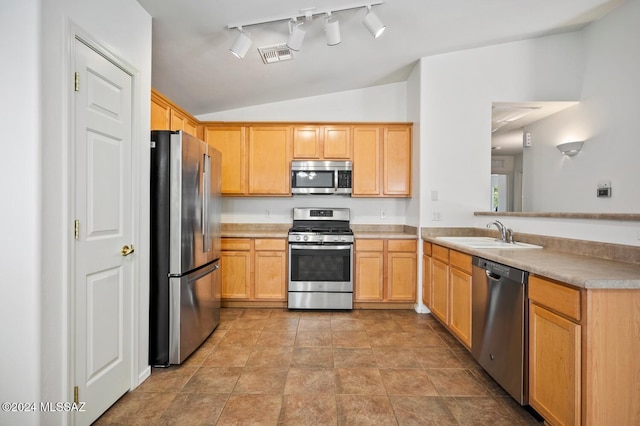 kitchen featuring lofted ceiling, sink, stainless steel appliances, kitchen peninsula, and light brown cabinets