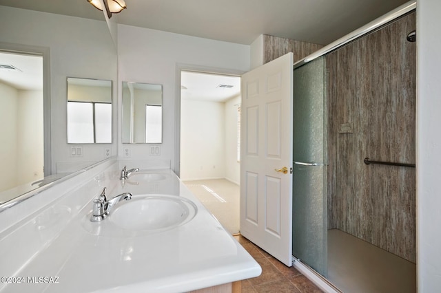 bathroom with sink, a shower with door, and tile patterned floors