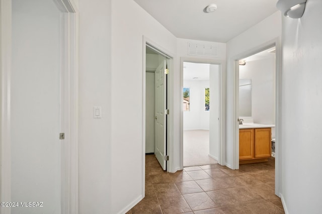 hallway with sink and light tile patterned floors