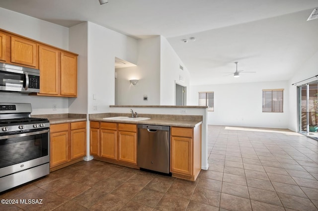 kitchen featuring lofted ceiling, sink, ceiling fan, appliances with stainless steel finishes, and kitchen peninsula