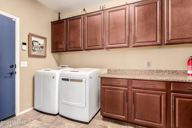 laundry area featuring washer and clothes dryer and cabinets