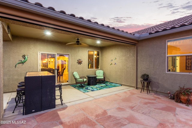 patio terrace at dusk featuring ceiling fan