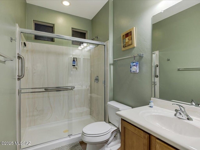 bathroom featuring walk in shower, vanity, and toilet