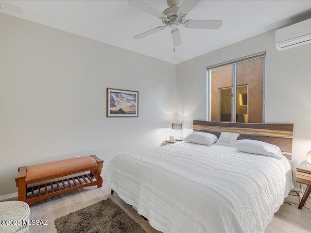 bedroom featuring ceiling fan, a wall mounted AC, and light wood-type flooring