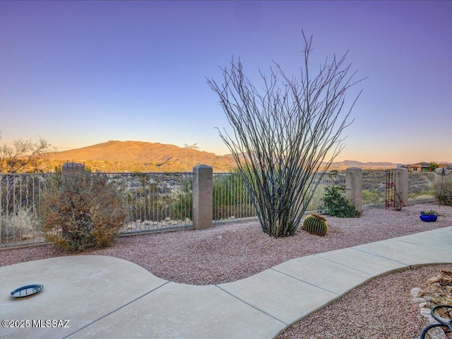 patio terrace at dusk featuring a mountain view