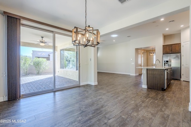 interior space featuring sink, ceiling fan with notable chandelier, and dark wood-type flooring