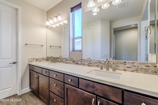 bathroom featuring vanity, decorative backsplash, and wood-type flooring