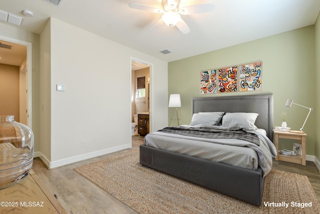 bedroom featuring ceiling fan, hardwood / wood-style floors, and ensuite bath