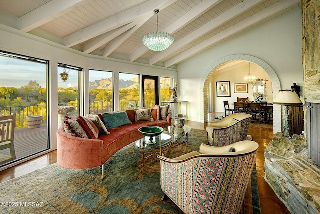 sunroom / solarium with lofted ceiling with beams, plenty of natural light, wood ceiling, and a chandelier