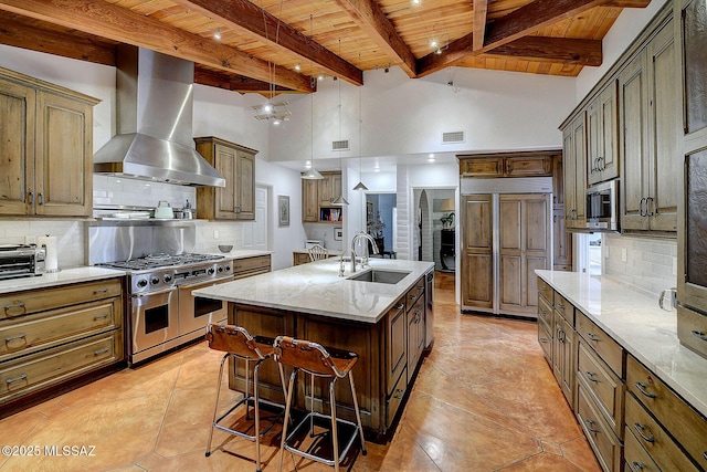 kitchen with sink, backsplash, high end appliances, a center island with sink, and wall chimney exhaust hood